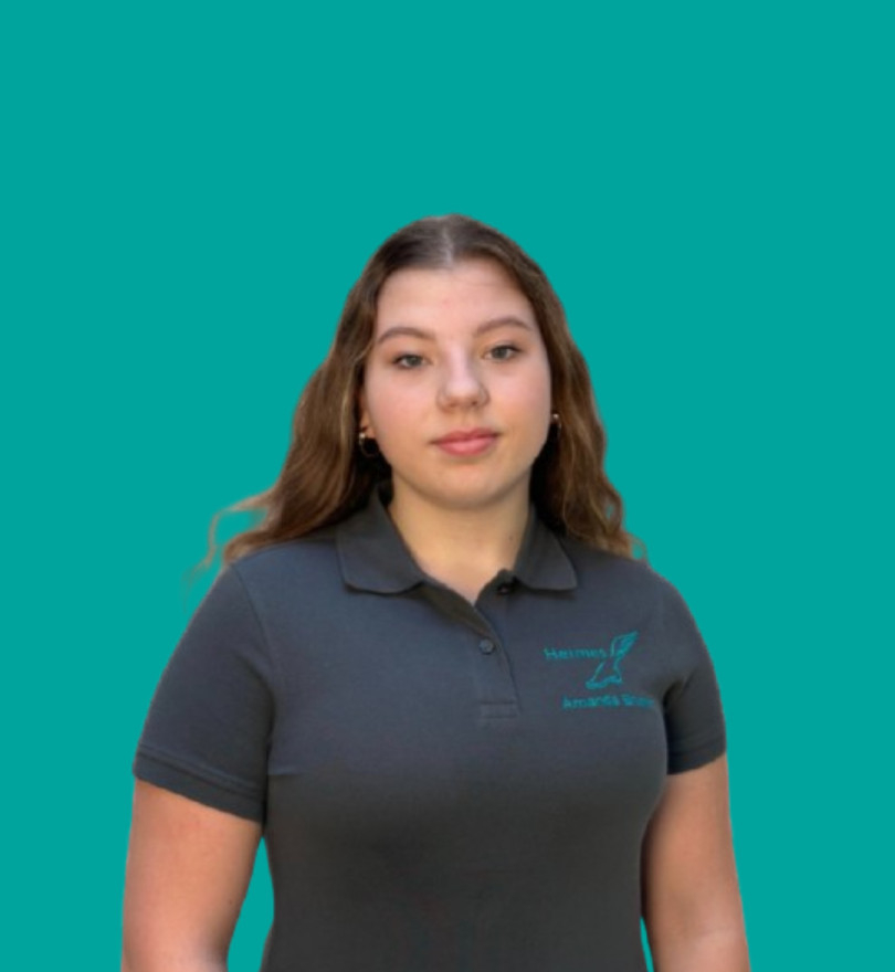 Team-Porträt einer Mitarbeiterin im Firmen-Poloshirt vor türkisfarbenem Hintergrund.